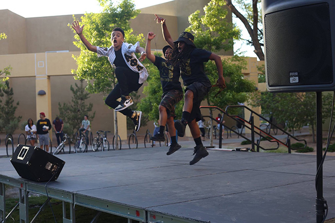 Alpha Phi Alpha - 3 black students jumping in the air as part of a stage performance