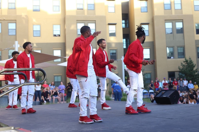 kappa alpha psi - male students standing on stage with white clothes and red shoes and jackets